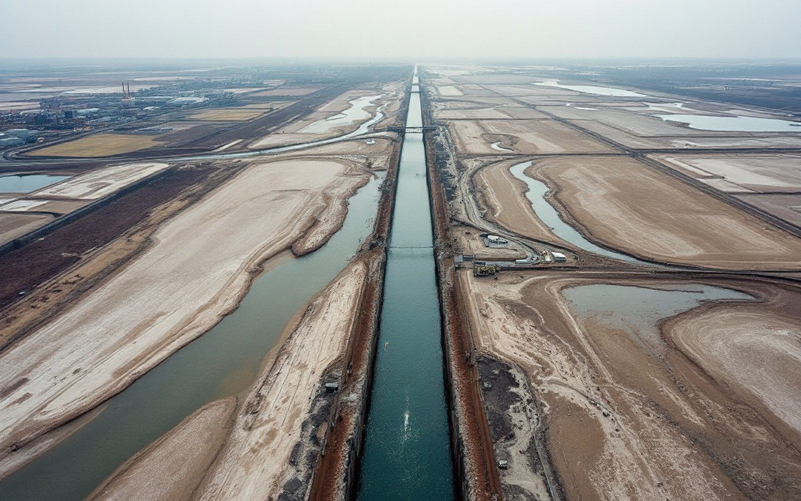 An aerial-height view of two rivers joining, sandbars visible at the junction